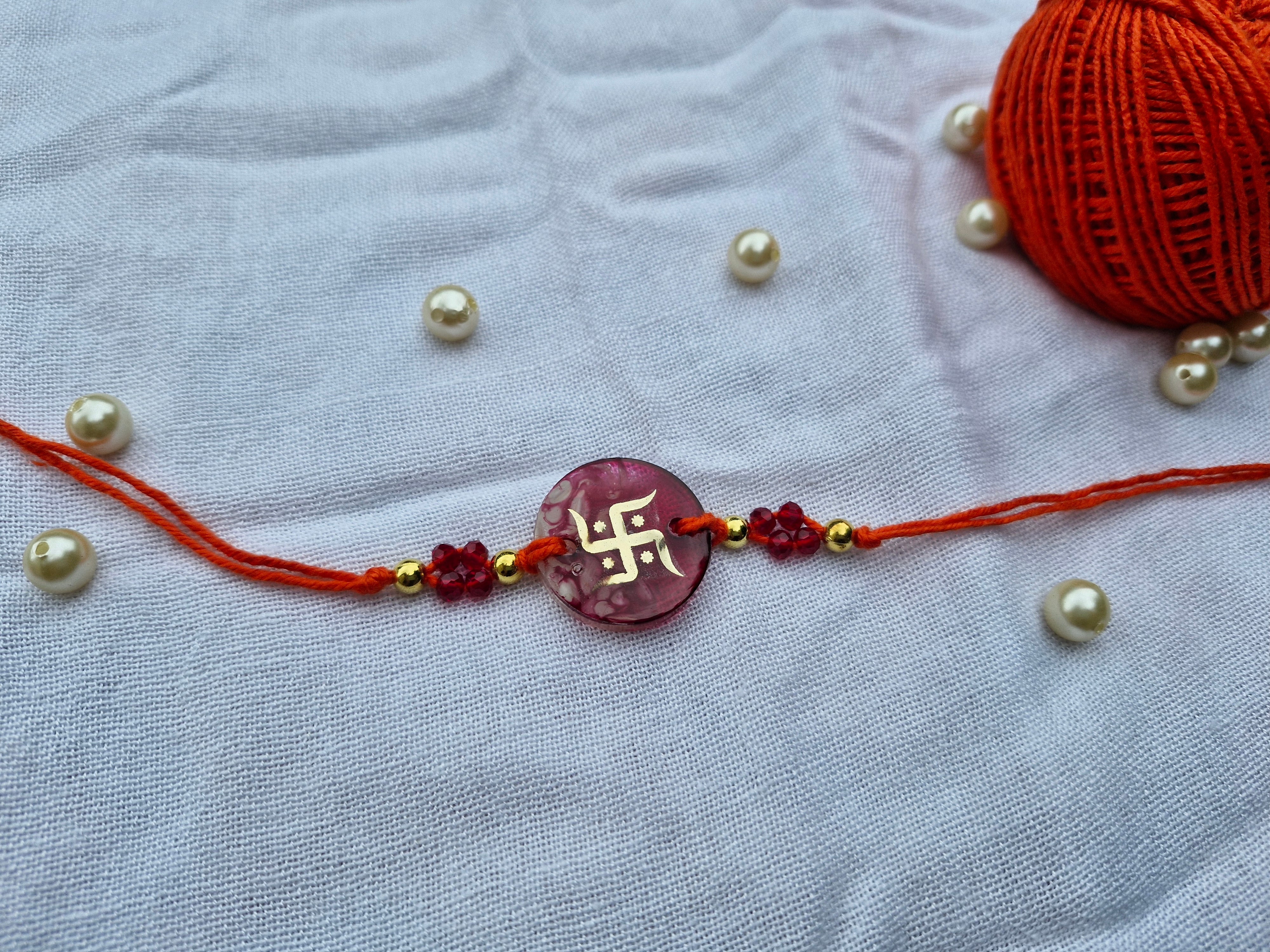 Traditional Swastik Rakhi – Red Resin with Crystal Beads