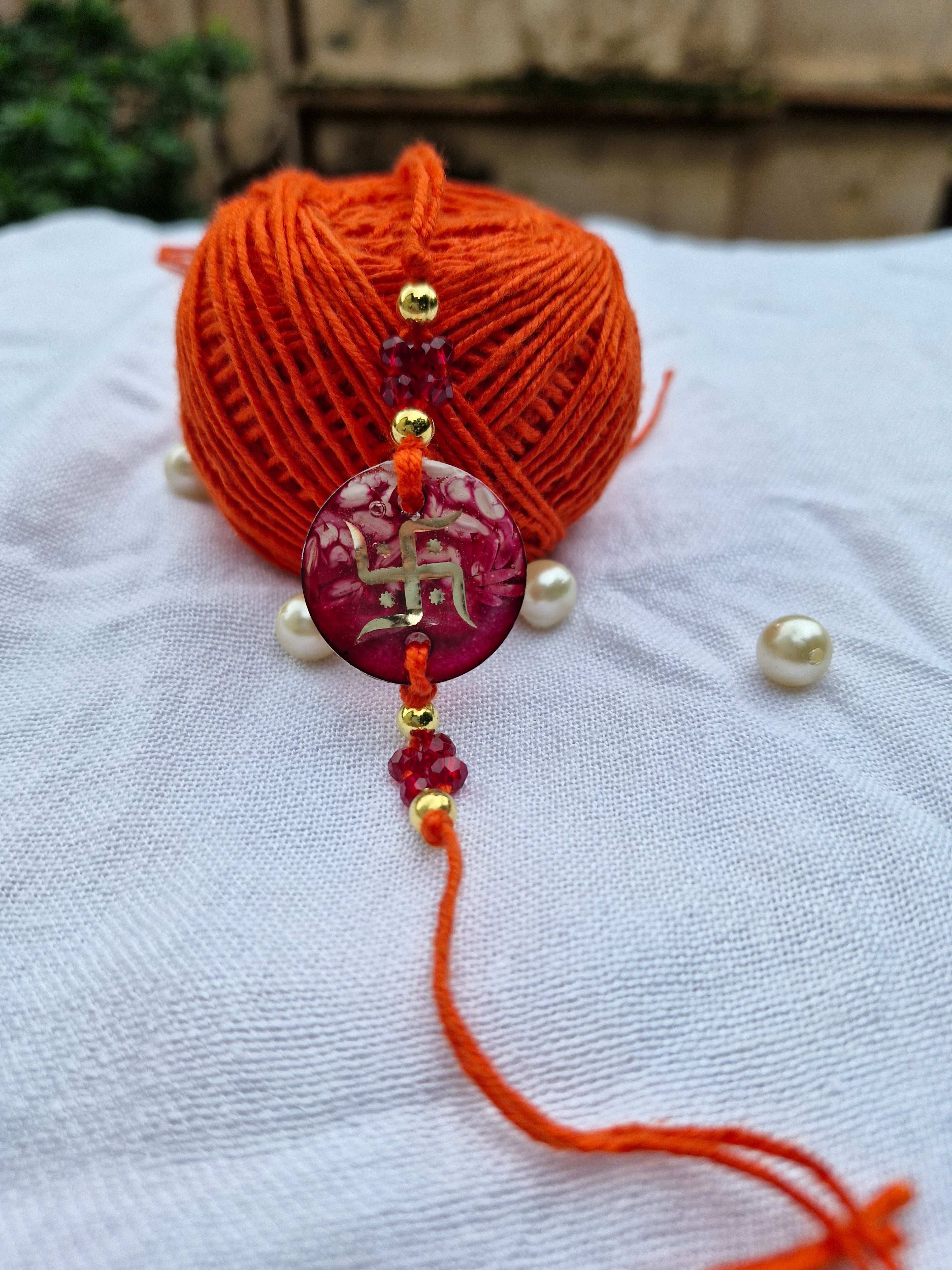 Traditional Swastik Rakhi – Red Resin with Crystal Beads