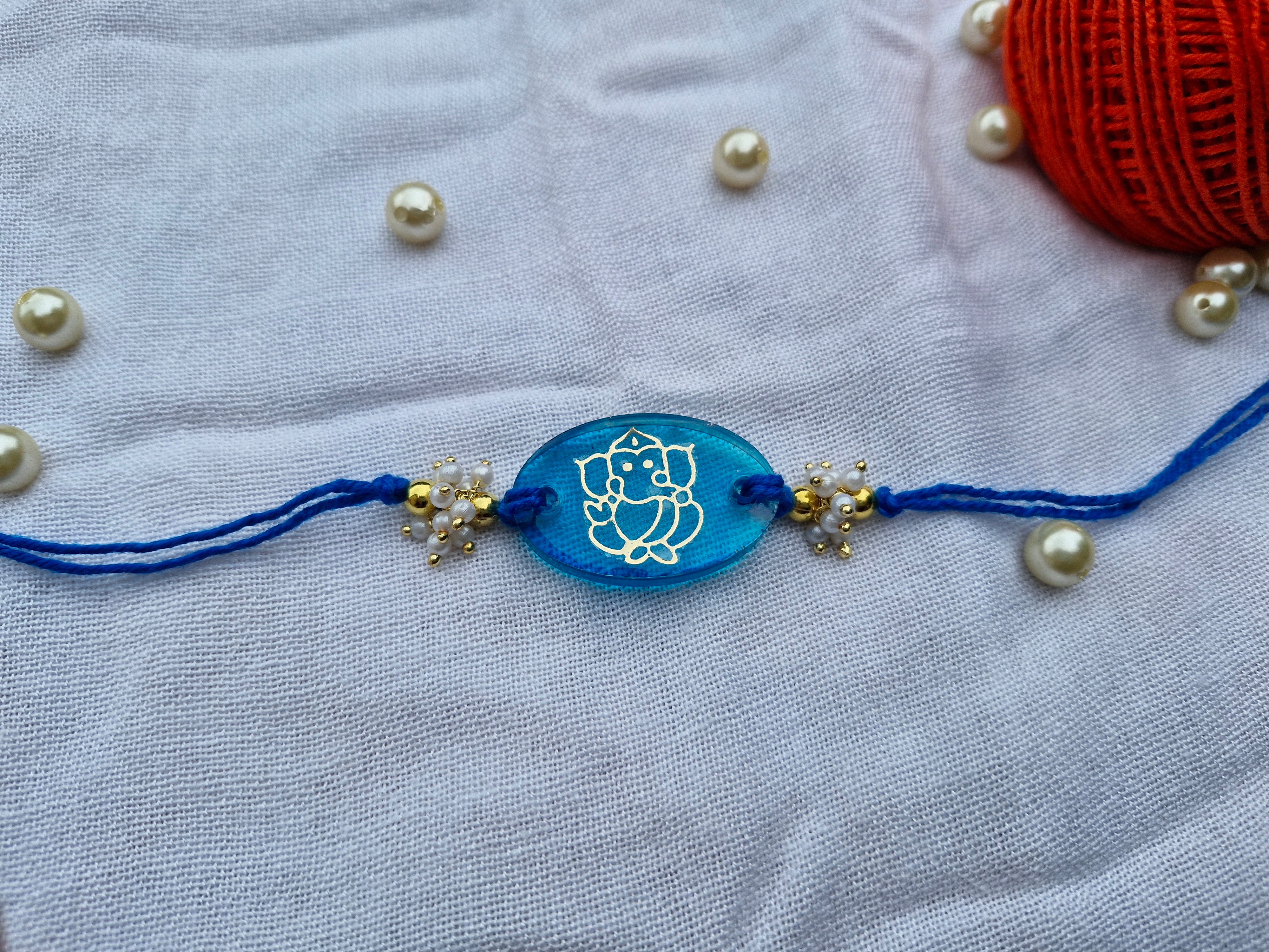 Blessings of Ganesha Rakhi – Blue Resin with Pearl Detailing