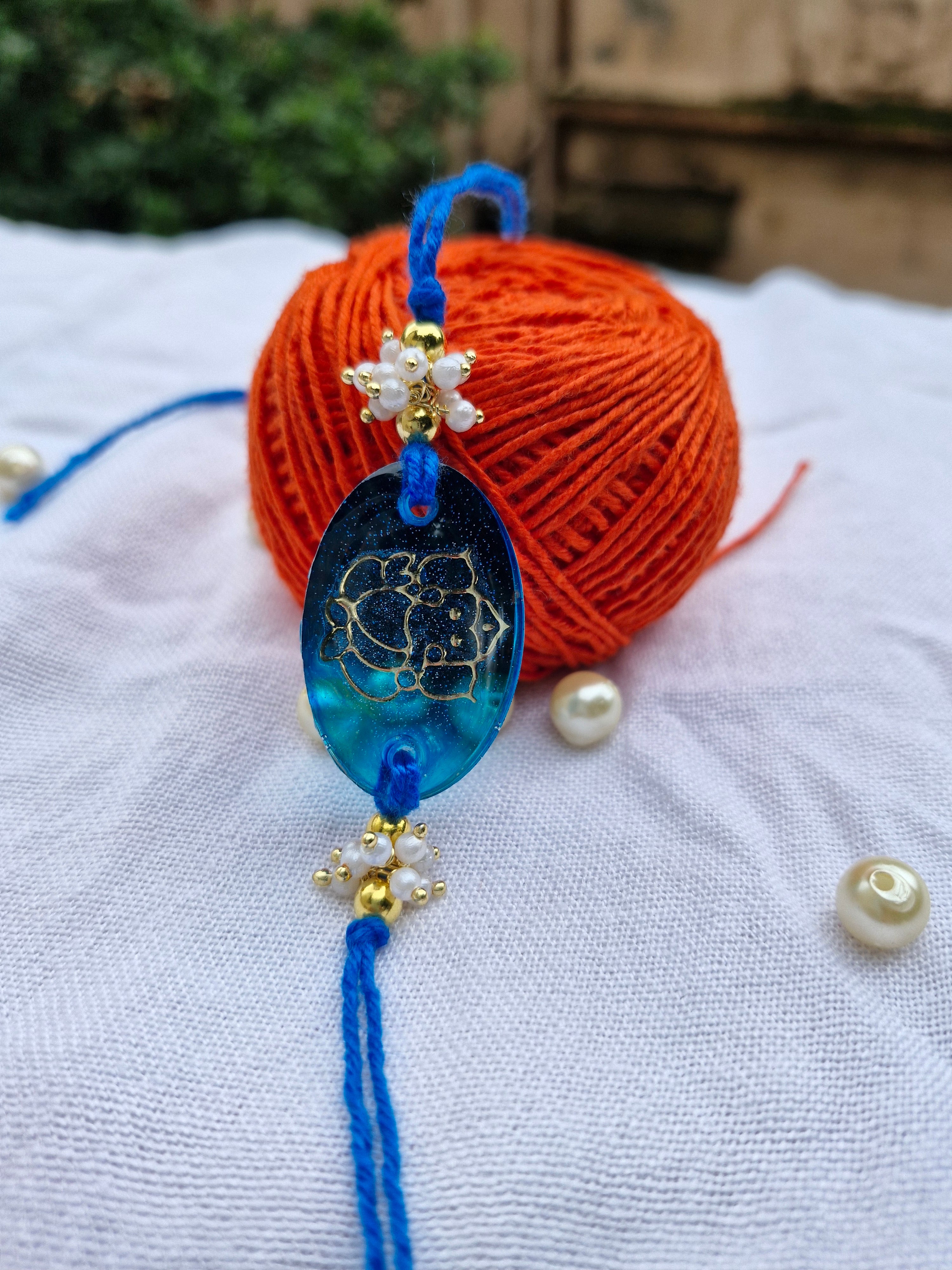 Blessings of Ganesha Rakhi – Blue Resin with Pearl Detailing