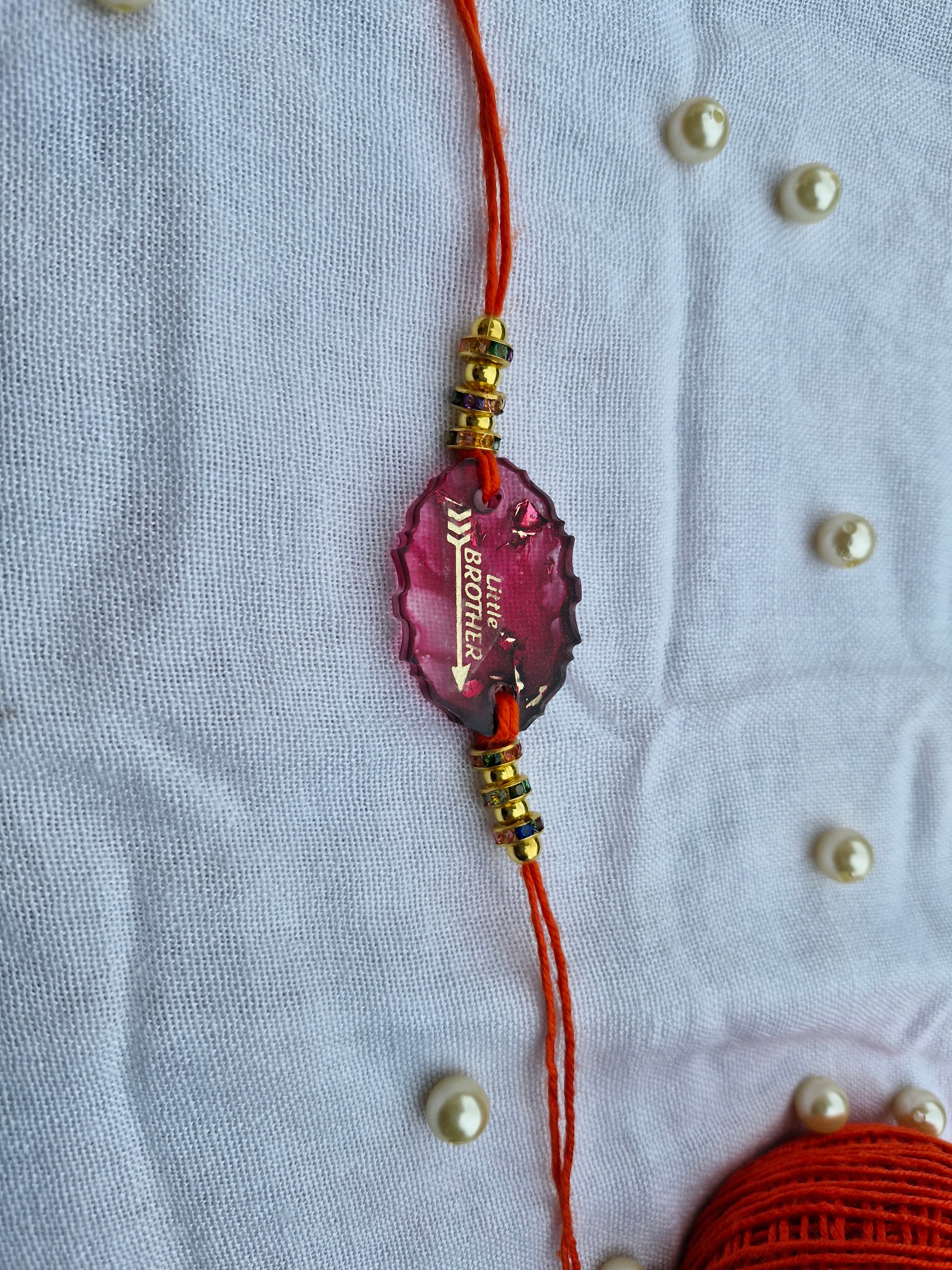 Little Brother Rakhi – Pink Resin Charm with Golden Accents